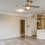 Spacious open floor plan living space adjacent to the kitchen with a ceiling fan.